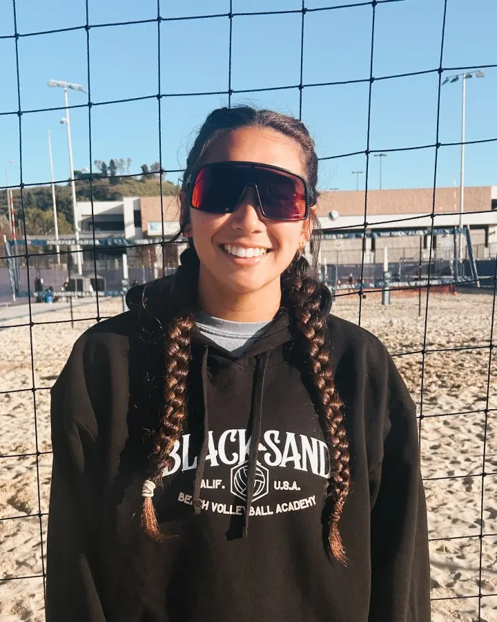 Coach Daylin Saiki at the net in a Black Sand hoodie