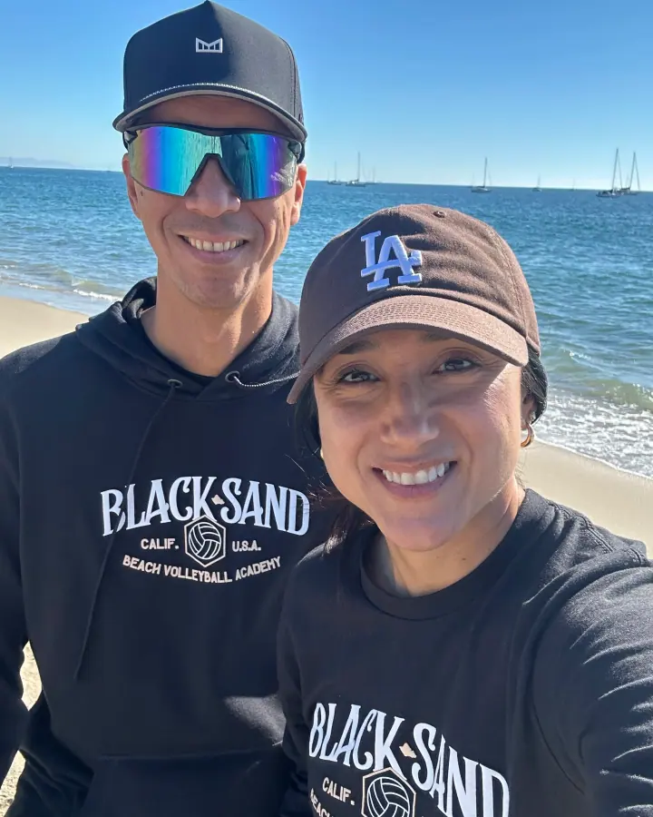 Adam and Crystal Black on the beach in Black Sand hoodies